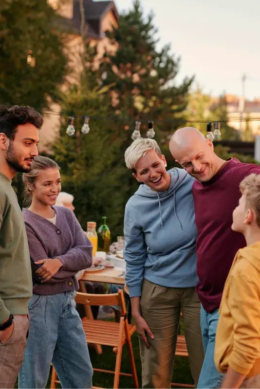 Nachbarn feiern gemeinsam eine Party und unterhalten sich fröhlich im Garten.